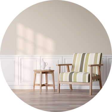 A small end table with a vase on it sits beside a chair in a neutral-colored room
