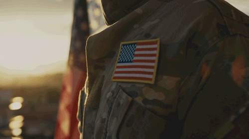 Thank You, Veterans in white text over video of a soldier placing a hand over their heart.